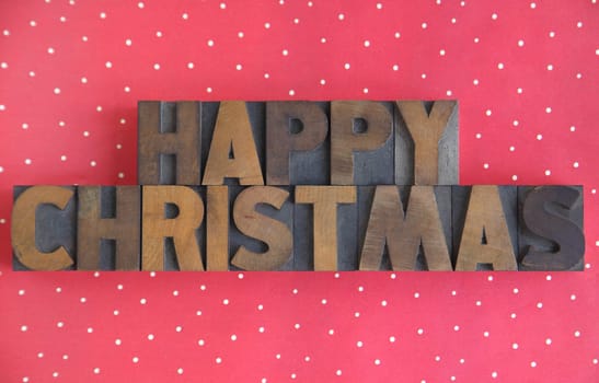 the words 'happy Christmas' in old wood type on a polka dot background