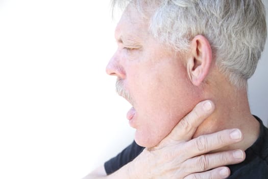 senior with mouth open and hand on jaw and neck