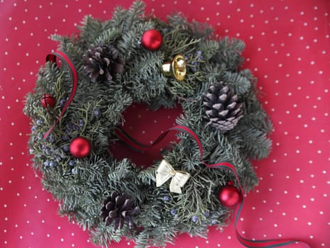 holiday decoration with pine cones, ornaments and a ribbon on a polka dot background