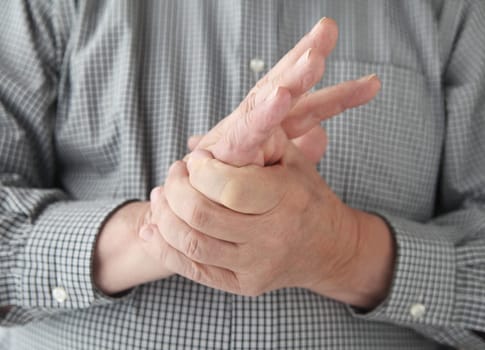 a man tries to restore feeling in his hand by squeezing