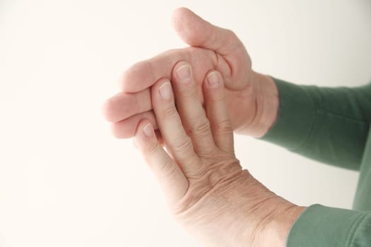 a senior man stretching his fingers