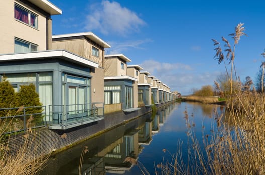 modern residential houses along a canal in almere, netherlands