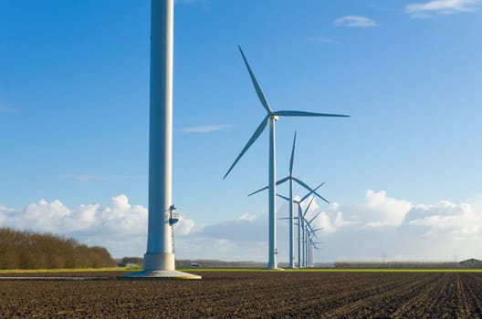 row of windmills in an agricultural landscape in the netherlands