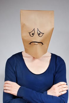 a sad looking person with a paper bag head