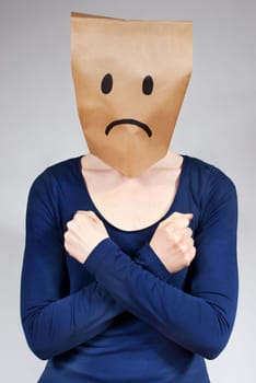 a sad looking person with a paper bag head defending itself