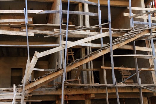 A very dangerous construction site with poorly constructed wooden scaffolding