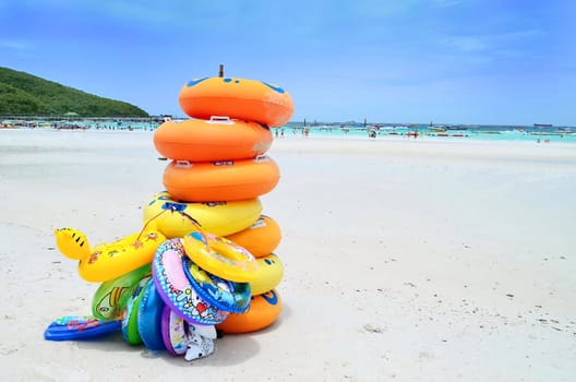 Stack of colorful swimming tubes on the beach