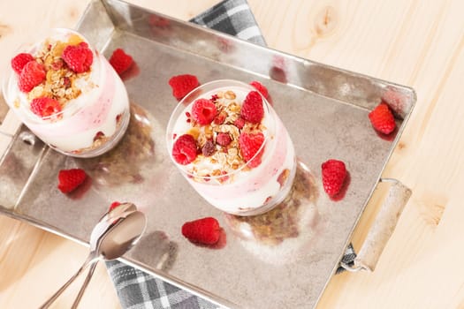 Muesli in a jar with raspberries from above on wood