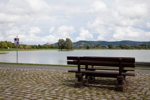 Bathing lake in the Mainaue recreation area (Kieswäsch) west of Kulmbach with Plassenburg and bench