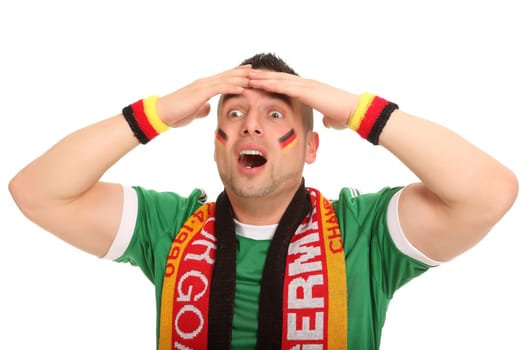 A football fan stands there and has a helpless expression. He touches his head with his hands.