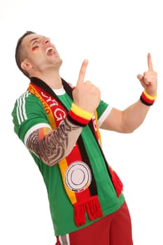A cheering football fan stands and throws both hands up. He seems to be roaring out success.