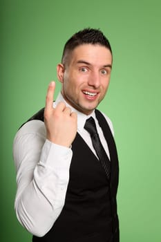 Businessman looking at camera with raised index finger and big eyes.