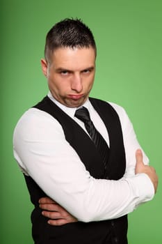 The photo shows a businessman standing very stubbornly in front of the camera with his arms crossed.