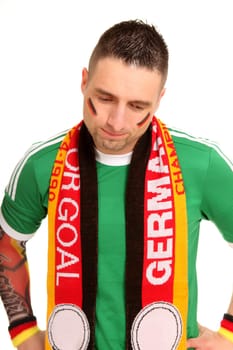 A man,dressed as a Germany fan,stands in front of the camera with his head bowed. He looks down sadly