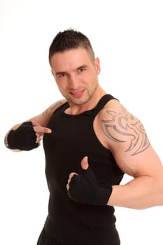 A young athlete stands there with his thumbs up and points directly at himself with his other hand.