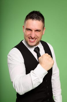 A young businessman has bent one arm powerfully and looks aggressively into the camera.