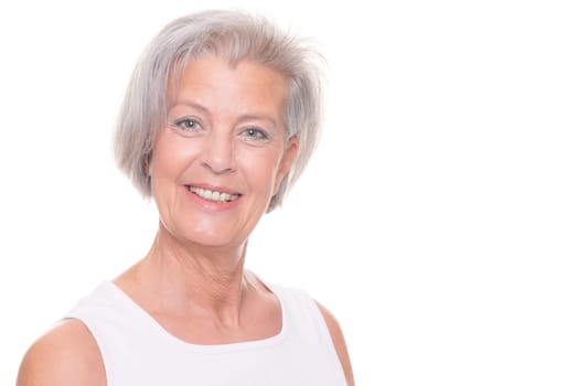 Smiling senior woman in front of white background