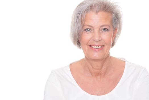 Smiling senior woman in front of white background