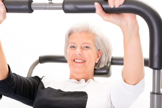 Active senior woman doing sports in front of white background