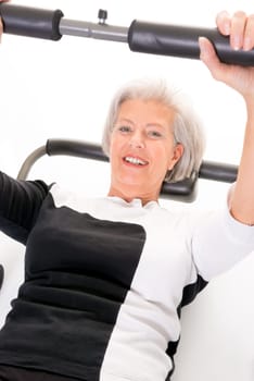 Active senior woman doing sports in front of white background
