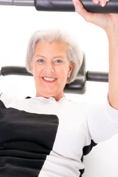 Active senior woman doing sports in front of white background