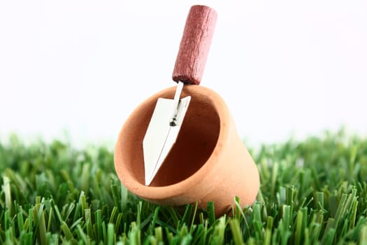 Plant pot with trowel on grass