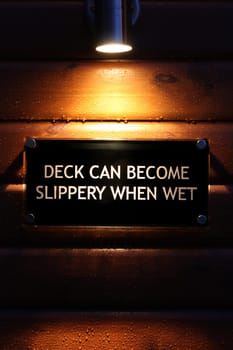 Lit warning sign on wet wood