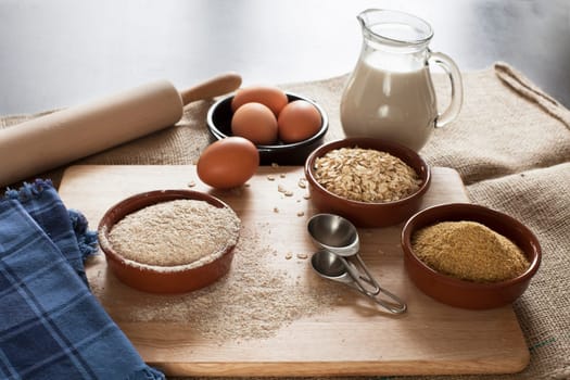 Ingredients for whole grain healthy bread, whole wheat flour, rolled oats and wheat germ with milk and eggs.