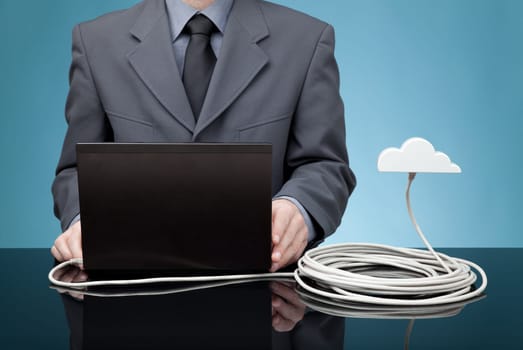 Cloud computing concept. Man send data from laptop to cloud via ethernet cable.
