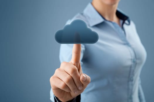 Cloud computing concept. Woman click on cloud icon ahead. Selective focused on finger and cloud.