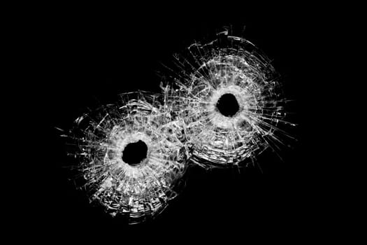 bullet holes in glass - authentic bullet holes closeup isolated on black