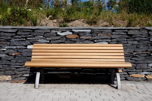 Wooden bench / garden bench in front of slate wall