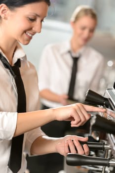 Smiling women waitress preparing coffee with machine