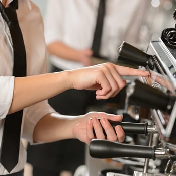 Waitress operating espresso machine coffee in house