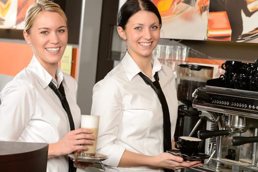 Cheerful waitresses serving hot coffee in bar in uniform