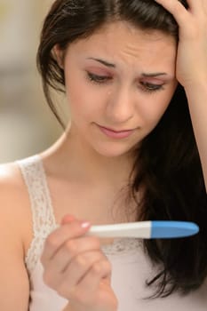Distraught girl waiting for pregnancy test result thinking about future