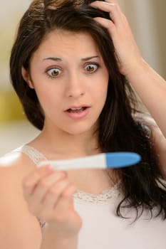 Worried woman looking at pregnancy test unhappy about result