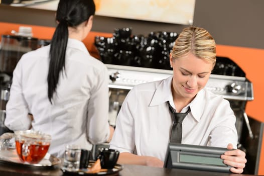 Happy waitresses working at cafe in uniform