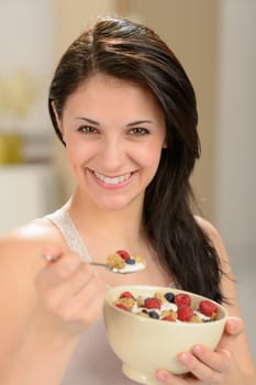 Attractive young woman eating a healthy bowl of cereal