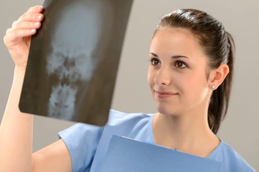 Female doctor holding and examining X-ray picture with skull