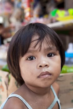 Asian child from impoverished area - natural portrait by a local market in the Philippines.
