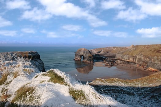 snow covered view of beach cliffs and the virgin rock in ballybunion county kerry ireland