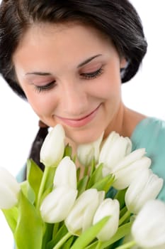Smiling delighted woman holding bouquet of white tulips