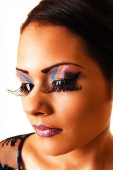 A very pretty face of a young woman with lovely makeup and long eyelashes and red lips in a closeup shoot with her eyes closed.