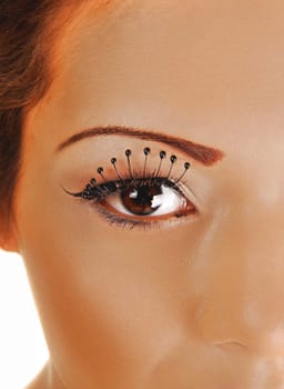 A closeup shoot if a woman's eye with long eyelashes, looking into the camera.