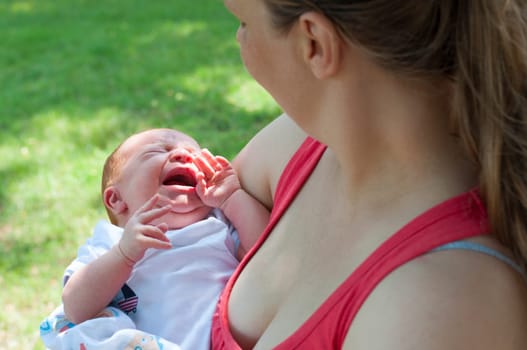 Crying Newborn Baby and Mother From Behind Outdoors