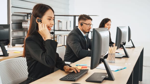 Business people wearing headset working in office to support remote customer or colleague. Call center, telemarketing, customer support agent provide service on telephone video conference call. Jivy