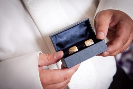 Man holds box with two cufflinks, jewelery