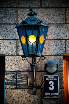 old blue beautiful lantern on old brick wall in street of Riga old town, Latvia