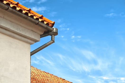 beautiful old roof tops with downtake tube and blue cloudy sky in background